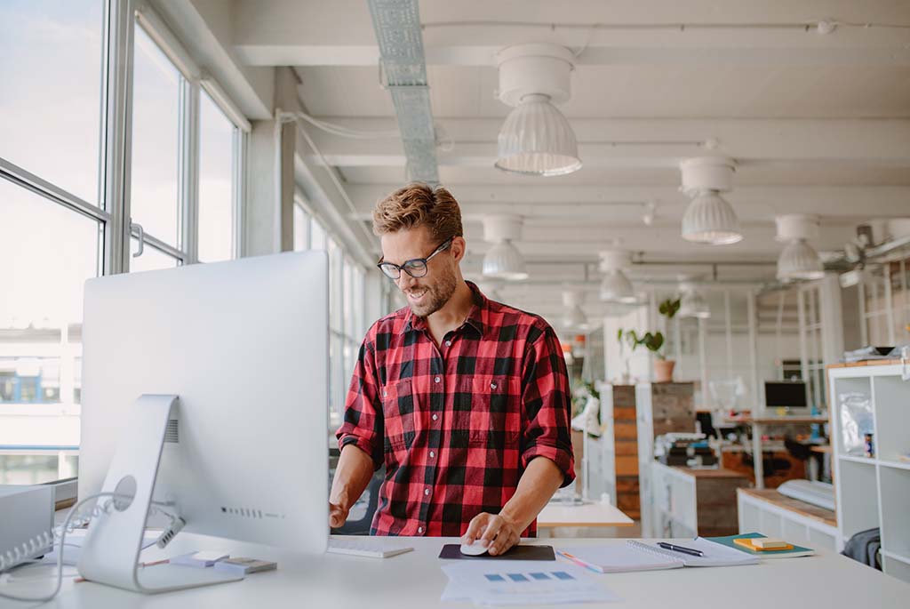 IT specialist smiling while working on computer at work