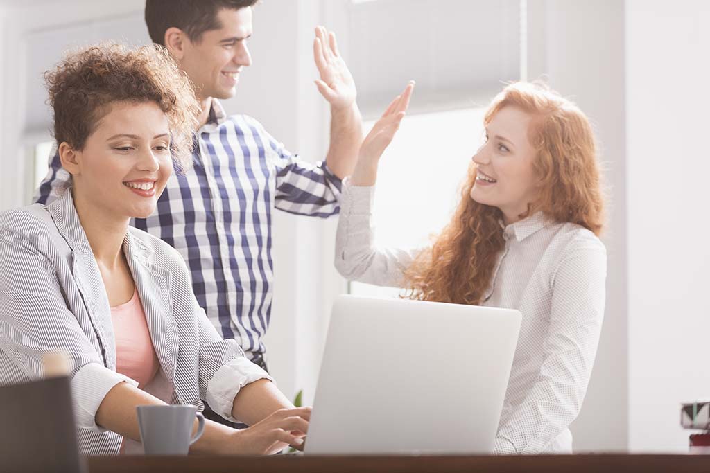 IT specialist high fiving team members