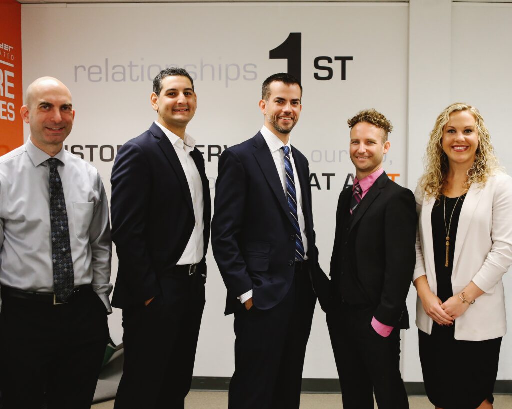 Four businessmen and one business woman posing for photo